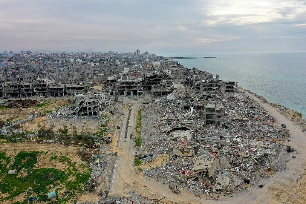 Aerial view of Israeli destruction in Beach refugee camp, Gaza Strip. Looking south with the coast on the right. The Port of Gaza is visible in the distance, projecting into the Mediterranean Sea.